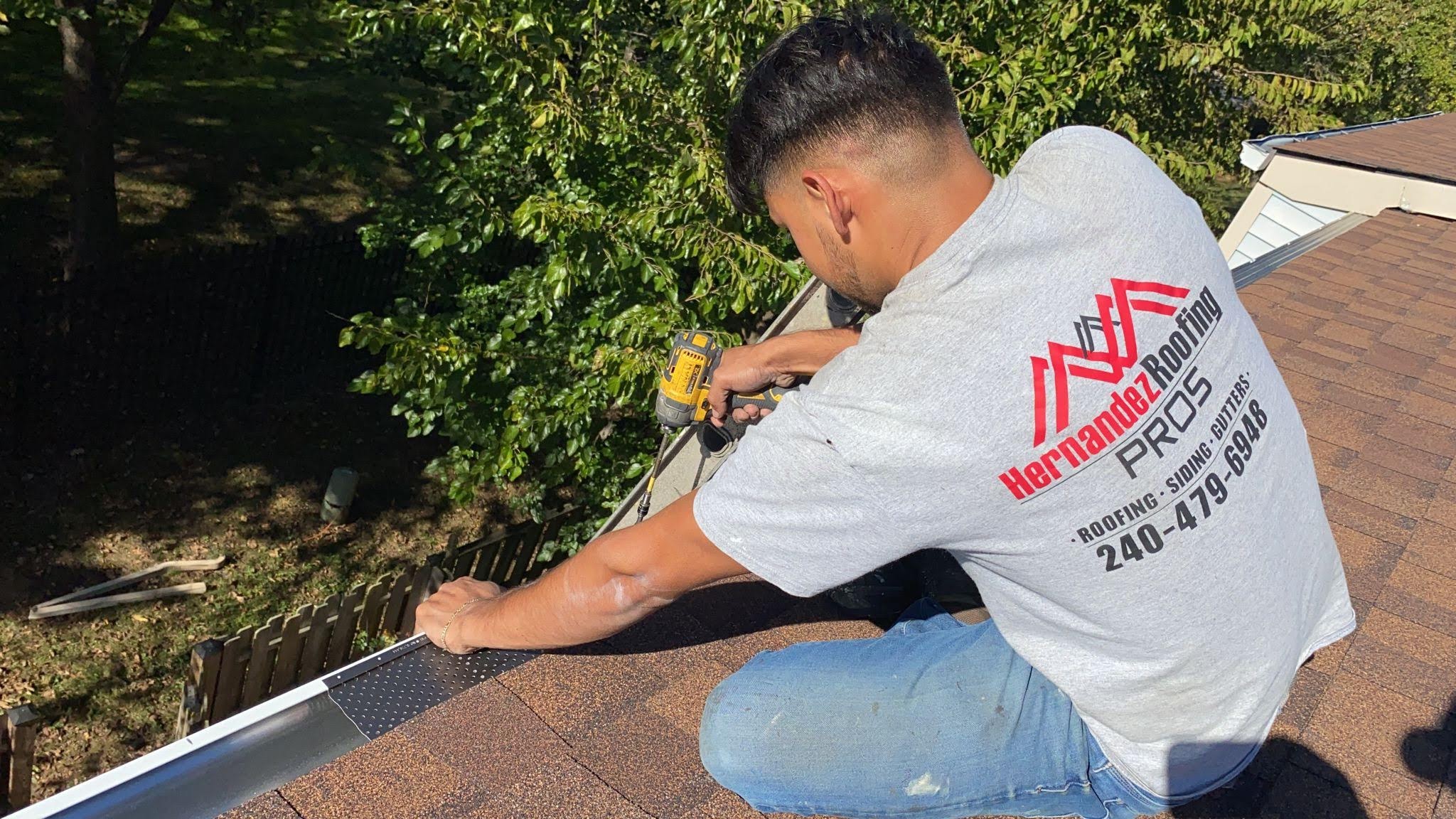 Hernandez Roofing Pros crew member installing gutter guard on a residential roof