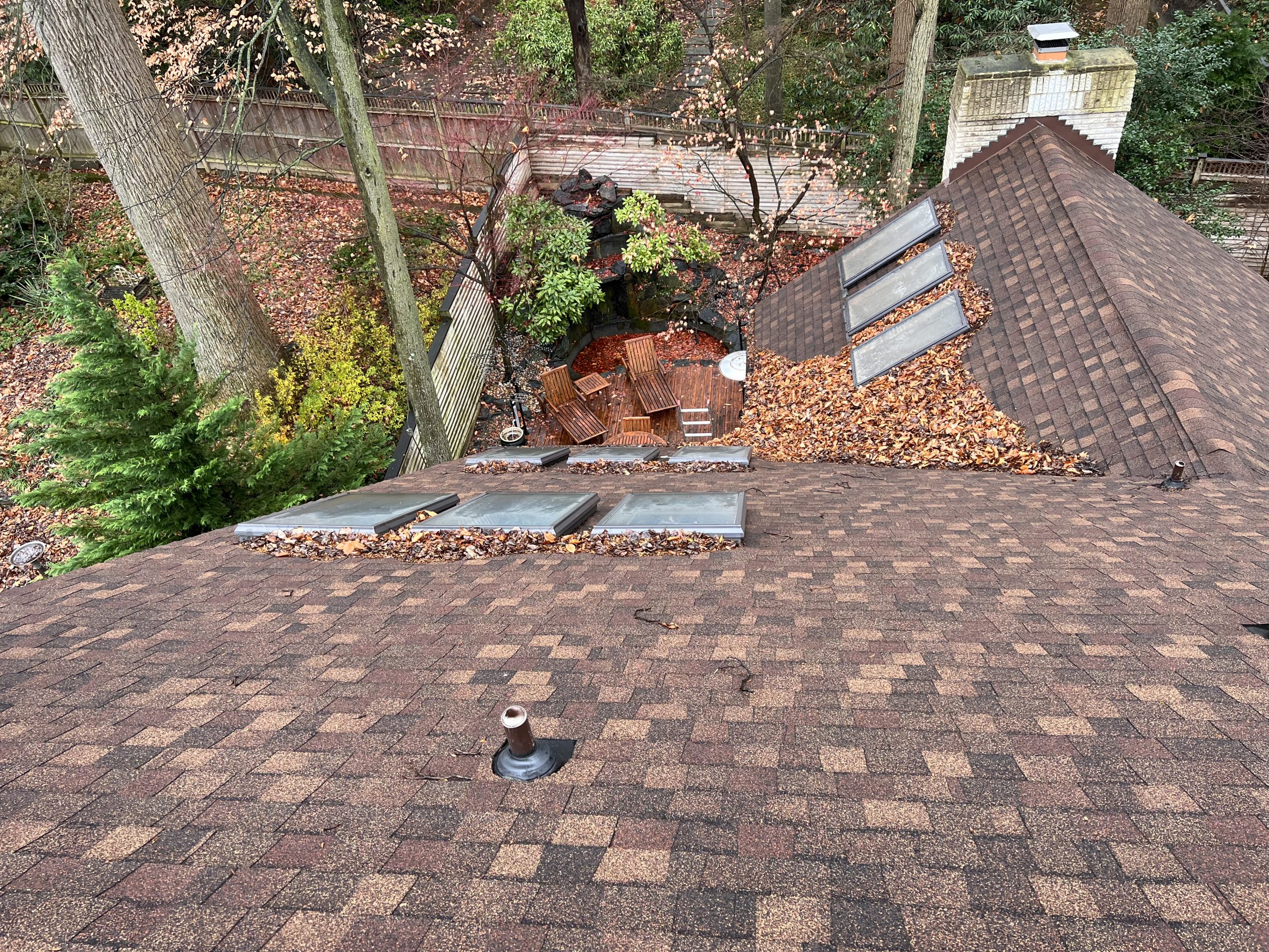 Aerial view of a large multi-section roof with several skylights over a courtyard.