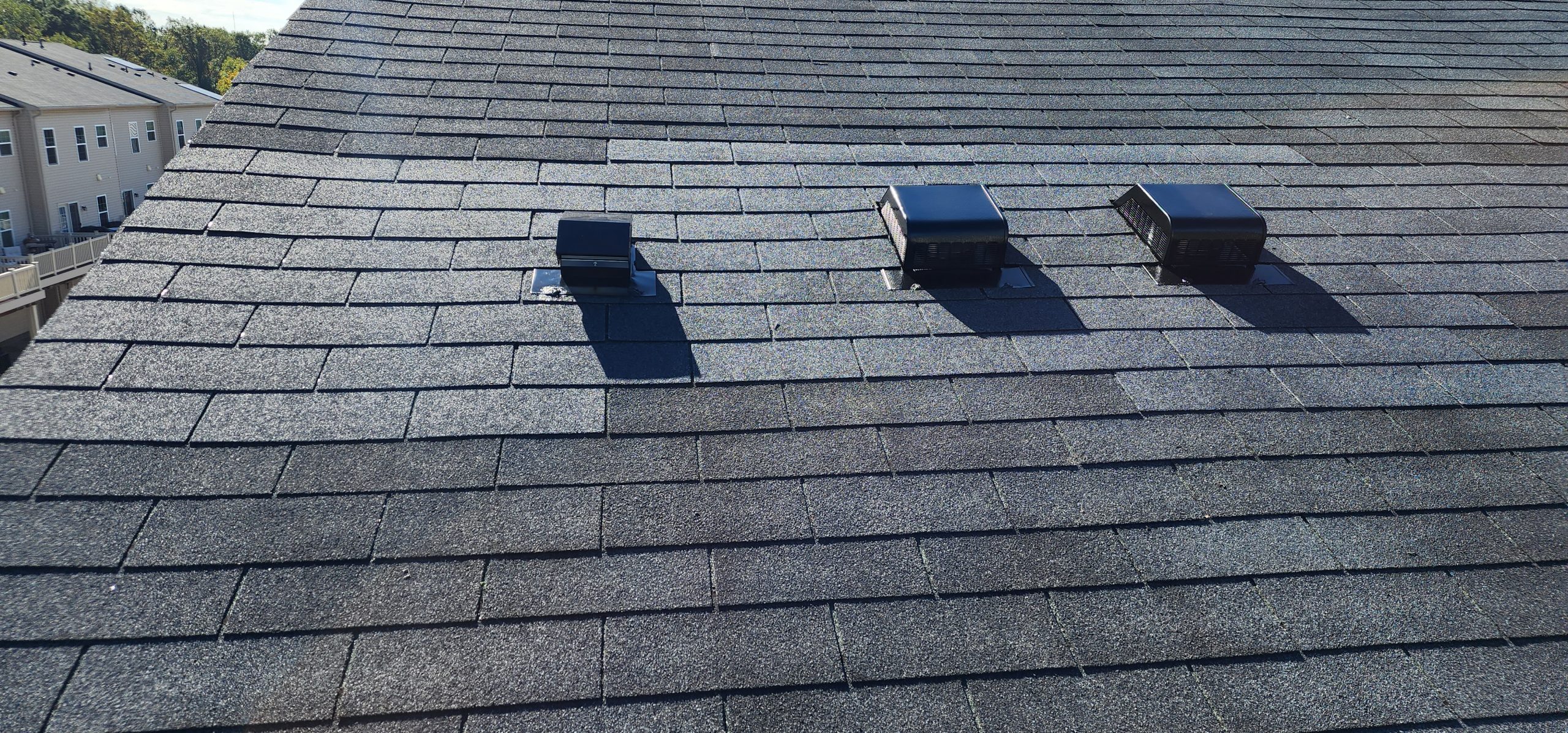 Finished architectural asphalt shingle roof with vents, on a Maryland townhome — completed by Hernandez Roofing Pros.