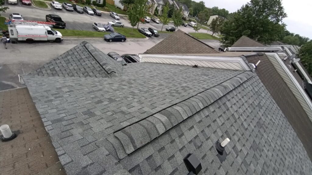 Aerial view of a finished grey architectural shingle roof with ridge caps and vents