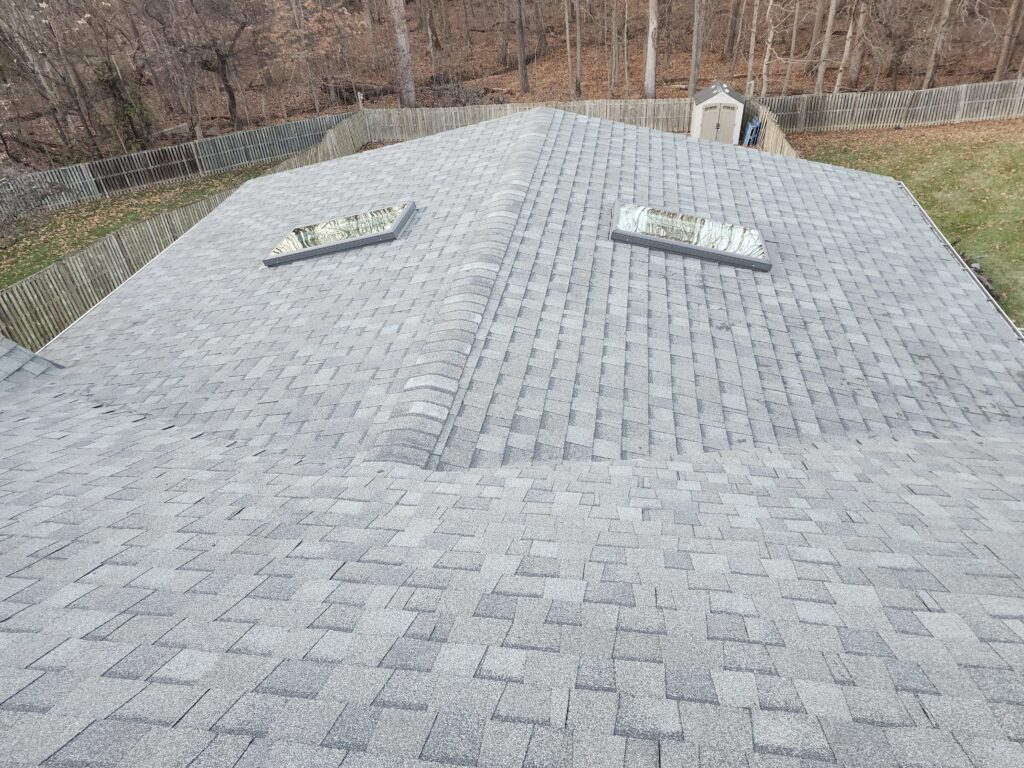 Completed shingle roof with two skylights set into the finished surface