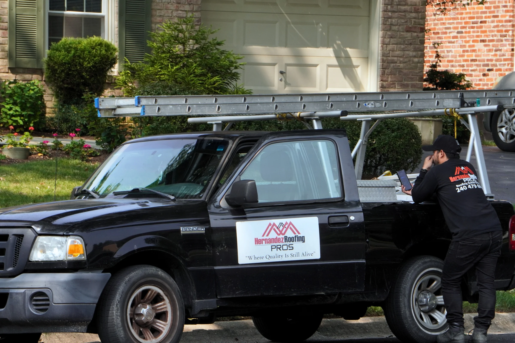 Hernandez Roofing Pros work truck being loaded with materials in a driveway