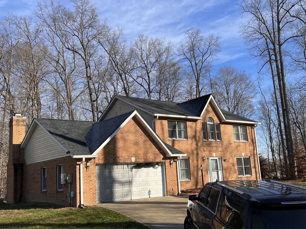 Brick home in Bethesda, Maryland with a completed dark architectural shingle roof under a clear winter sky