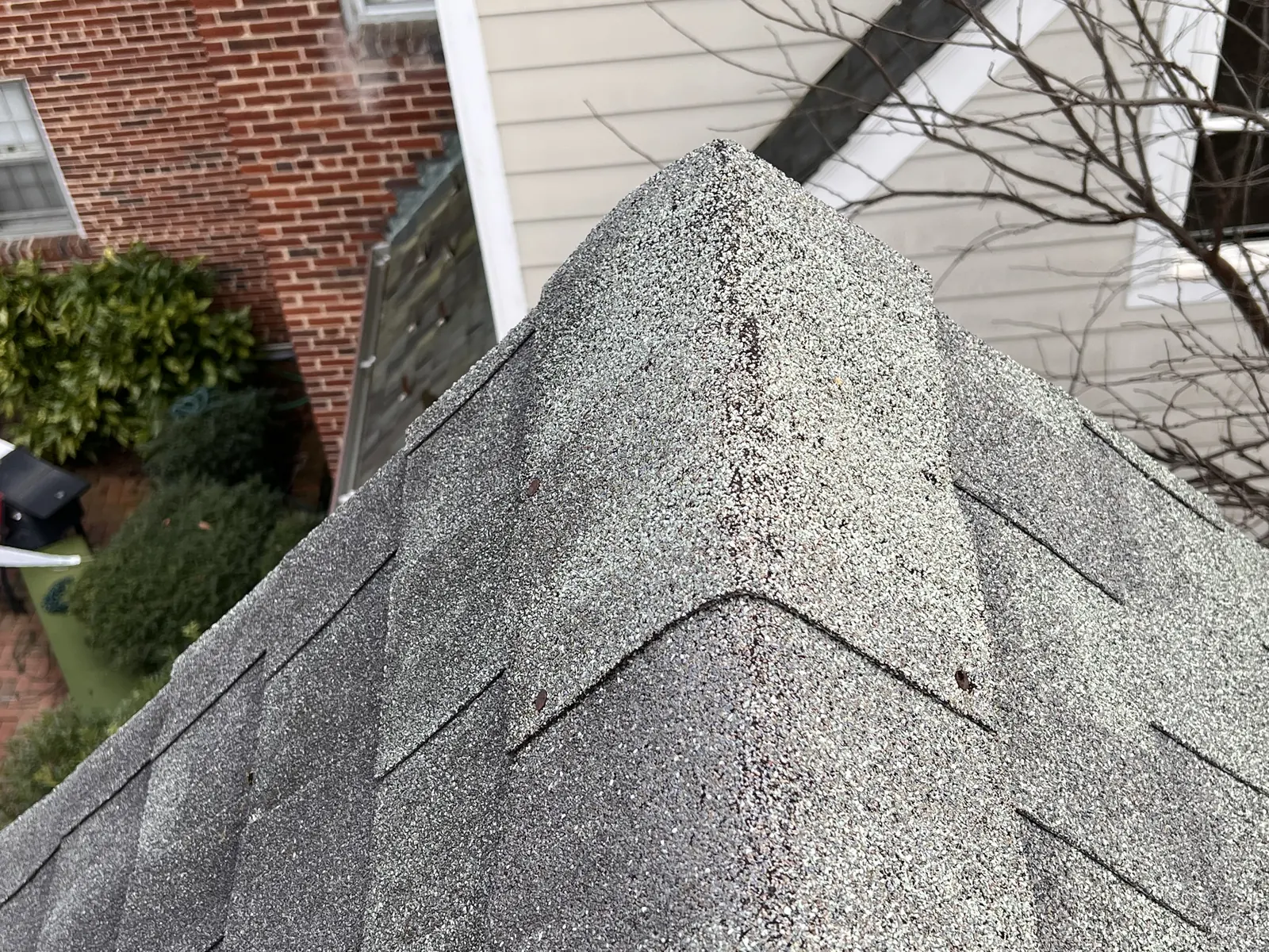 Worn shingles along a hip and ridge line, documented during a roof maintenance visit